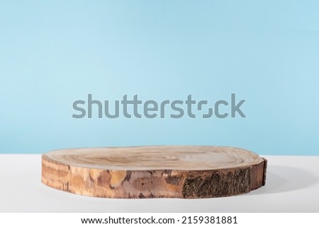 Background for cosmetic product presentation, wooden podium showcase on blue background for cosmetics perfume and jewellery minimalist display. Empty stage pedestal for beauty products. Front view