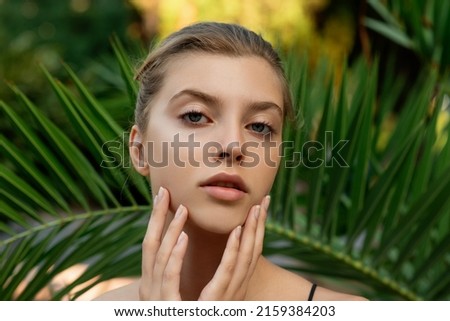 Beautiful young woman with clean perfect skin in tropical green leaves. Portrait of attractive beauty model girl on nature background. SPA wellness, body care and skincare concept. Selective focus Royalty-Free Stock Photo #2159384203