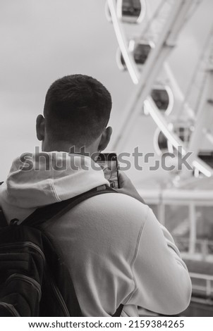 Young man photographing the view of eye-wheel in Scheveningen beach of Den Haag (the Hague) in the Netherlands 1