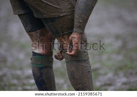A closeup of dirty rugby players in the field