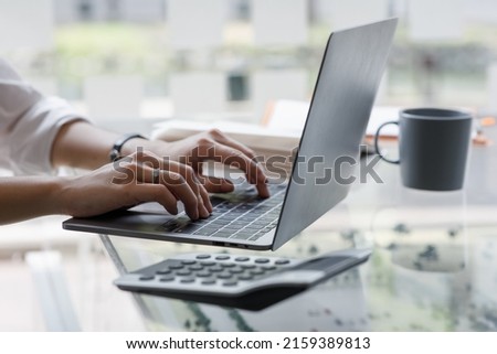 Close up of hand Asian businesswoman working on a laptop computer isolated over white background