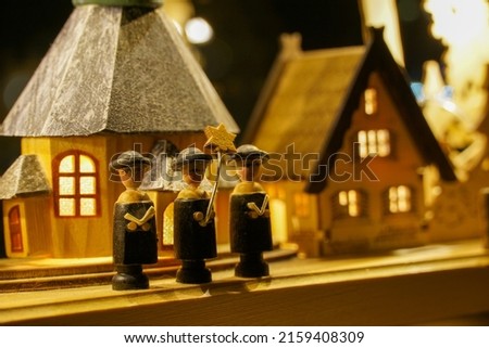 a close up shot of three Vintage Wood Finger carol singing Dolls in a Christmas scene