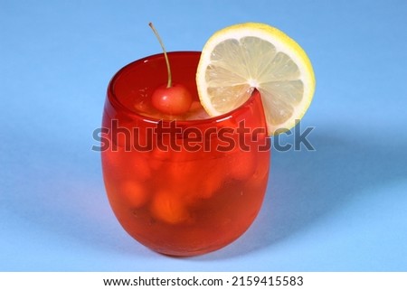 Glass of iced water with lemon and cherry
