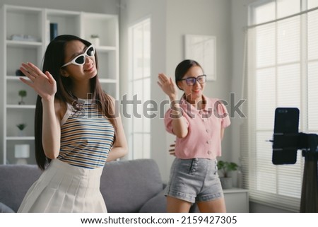 Asian young woman with her friend er created her dancing video by smartphone camera together To share video on social media application Royalty-Free Stock Photo #2159427305