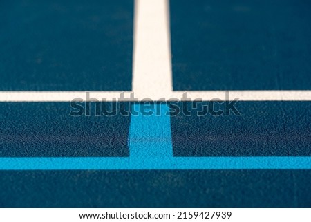 Blue tennis courts with white lines and light blue pickleball lines	
