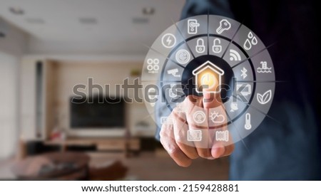 Man hand point smarth home GUI in livingroom. Hand use smart screen smart home automation assistant on a virtual screen and a user touching a button Royalty-Free Stock Photo #2159428881