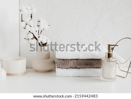 Spa, bathroom background. Towels on white desk near white wall and interior accessories with copy space.  Neutral beige colors. Royalty-Free Stock Photo #2159442483