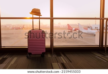 Travel concept with Pink luggage as hat in the airport terminal waiting area, summer vacation concept, traveling and enjoying concept Royalty-Free Stock Photo #2159455033