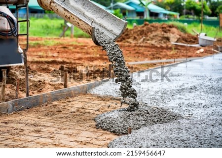 Construction workers supervise the pouring of concrete on the construction site. Royalty-Free Stock Photo #2159456647