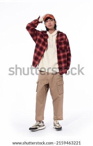 fashion model. Young man with hairstyle in paid shirt ,hoodie ,hat on white background

