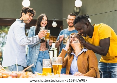 Moments of celebration in the family, young adoptive son covers his mother’s eyes to make a surprise, extended family party concept