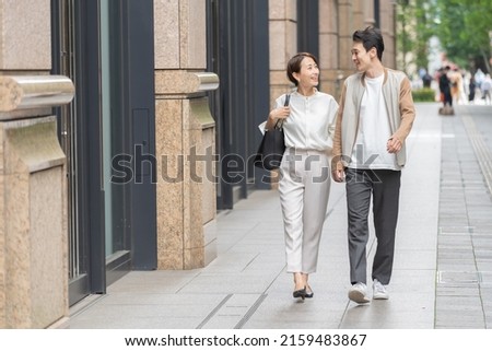 A lovely Japanese couple walking in the city Royalty-Free Stock Photo #2159483867