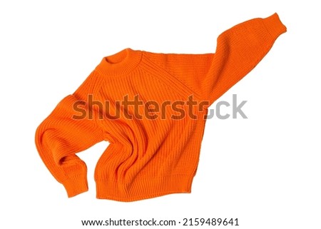 orange wool sweater, levitates like a superhero, one hand up, on a white background, isolate Royalty-Free Stock Photo #2159489641