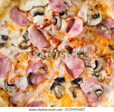 close up of juicy pizza with ham, mushrooms and cheese.