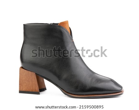 Women's autumn ankle black leather boots with black zip and average brown heels, isolated white background. Right side view. Fashion shoes. Photoshoot for shoe shop concept.