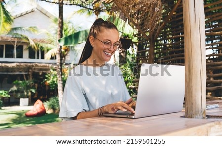 Hipster girl with laptop computer connecting to 4G wireless for browsing social media working remotely at terrace, joyful female chatting in networks spending free time for searching content text Royalty-Free Stock Photo #2159501255