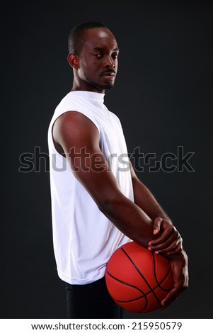Young african american basketball player over black background