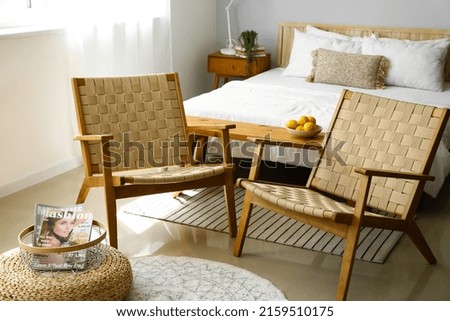 Interior of modern bedroom with wicker armchairs