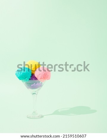 Creative concept made of colorful ice cream scoops on a pastel green background. Minimal summer concept. Copy space