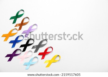 Different awareness ribbons on light background. World Cancer Day concept