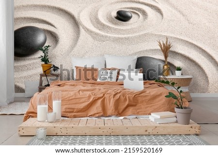 Stylish interior of modern bedroom with printed spa stones and sand on wall