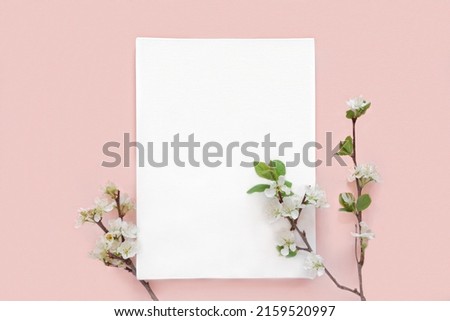 Blank greeting card, invitation mockup. Apple flowers, blossoming plant on pink table background. Flat lay, top view. Copyspace. Canvas mock up. Modern Minimal business brand template. Soft shadow