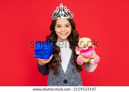 happy child in queen crown. princess in tiara hold box. kid with present. teen girl
