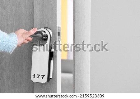 Woman opening door of hotel room, closeup