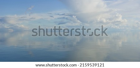 sky and water. a calm landscape of clouds reflecting in the water Royalty-Free Stock Photo #2159539121