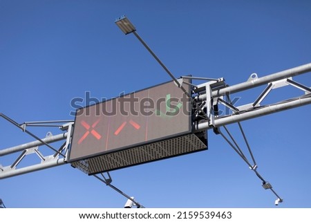 Traffic sign over road. Screen on track. Electronic scoreboard with signs for drivers. Steel construction on track.