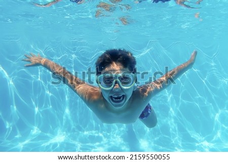 Little kid diving into a swimming pool
