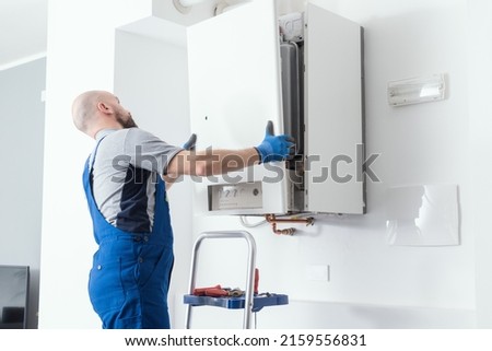 Professional engineer doing a boiler inspection at home Royalty-Free Stock Photo #2159556831