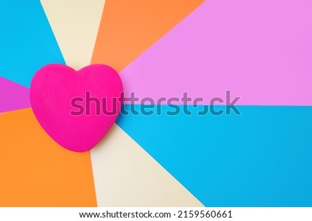 Large red heart on a multicolored abstract background with copy space.