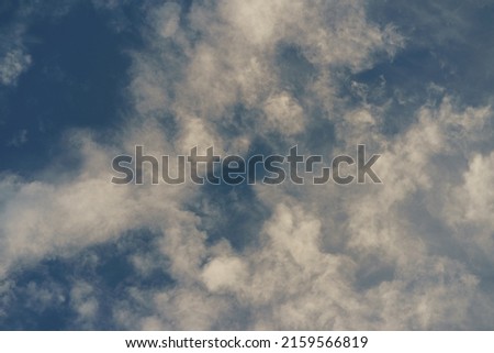 Photography of blue spring sky with white fluffy light clouds. Concepts of the beauty in nature, freedom and fresh air. A lot of sunlight.