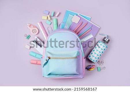 Opened School backpack with stationery in pastel color on pink background. Concept back to school. School supplies. Royalty-Free Stock Photo #2159568167