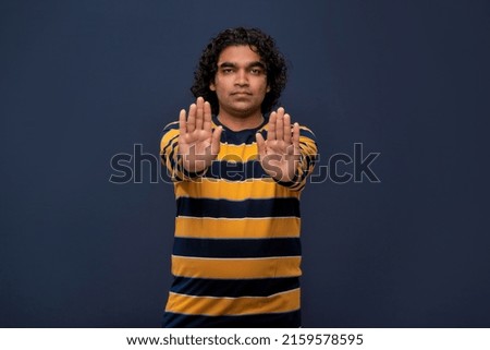 Portrait of a man crossing hands and showing palm, stop gesture, warning of end finish, forbidden way. indoor studio shot on gray background