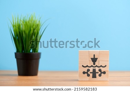 Ecology concept, wooden blocks with icon of tidal turbine energy eco power alternative electric renewable, on blue background