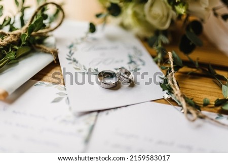 Stylish rings, flowers on wooden table background. Letters from the bride and groom. Vows. Engagement. Luxury marriage and wedding accessory concept. Royalty-Free Stock Photo #2159583017