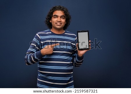 Young handsome young man, businessman showing a blank screen of smartphone or mobile or tablet phone on grey background 