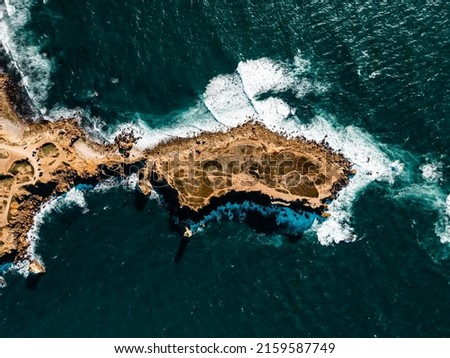 Areal view of atlantic ocean hitting the granite rocks on the coast. rocky environment with amazing color of the ocean in Canary island Spain