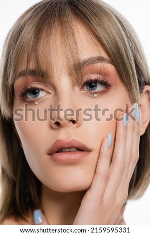 pretty young woman with makeup and shiny rhinestones under blue eyes isolated on white Royalty-Free Stock Photo #2159595331