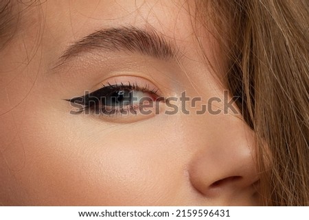 Glamour close-up portrait of beautiful woman model face with winged black eyeliner make-up, clean skin on white background. Long eyelashes and thick eyebrows. Royalty-Free Stock Photo #2159596431
