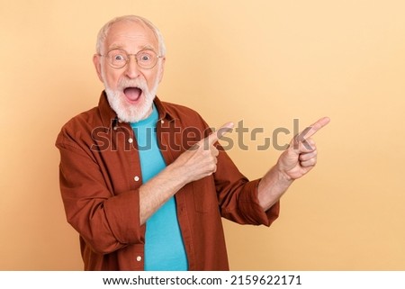 Photo of hooray elder grey hairdo man indicate empty space wear spectacles brown shirt isolated on beige color background Royalty-Free Stock Photo #2159622171