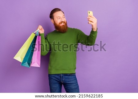 Photo of handsome positive man make video blog streaming during shopping time isolated on violet color background
