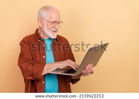 Photo of mature skilled businessman working remotely on new project start-up isolated on beige color background