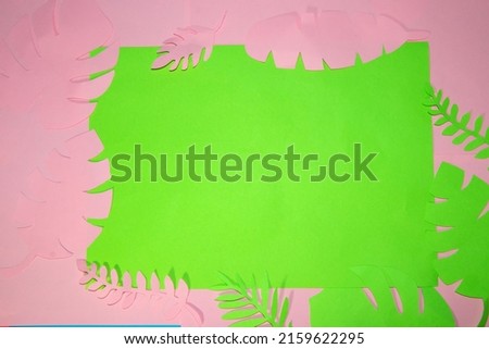 pink background with green paper in the middle as copy space on a frame of green paper leaf pink pink colors, creative summer art design, trendy colors