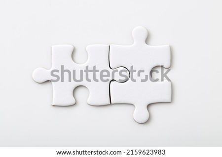 Two white blank puzzle pieces on a white background Merging different elements into a whole Royalty-Free Stock Photo #2159623983