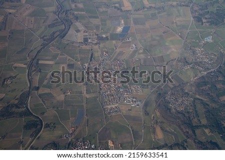Typical Bavarian small town or village with squares, roads and blocks, spring aerial view from the plane. Beauty of European nature with fileds, rivers, lakes and forests. Earth from above. 