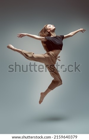 Beautiful modern ballet dancer girl flies in jump. Dance expression. Contemporary ballet. Full-length studio portrait. Royalty-Free Stock Photo #2159640379