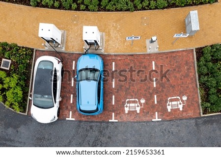 An aerial view directly above electric cars being charged at a motorway service station car charging station Royalty-Free Stock Photo #2159653361
